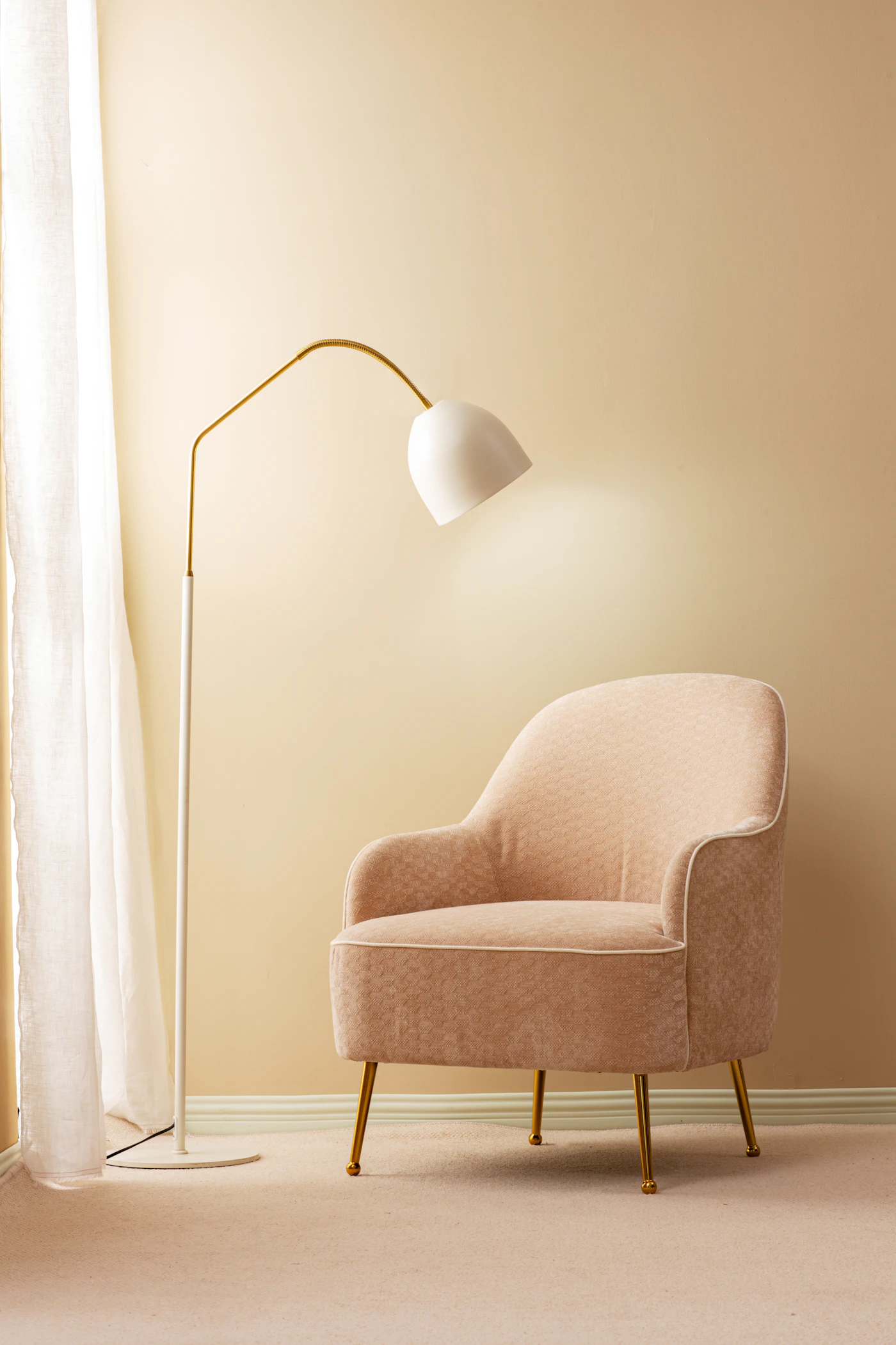 Messing vloerlamp naast een zachte fauteuil