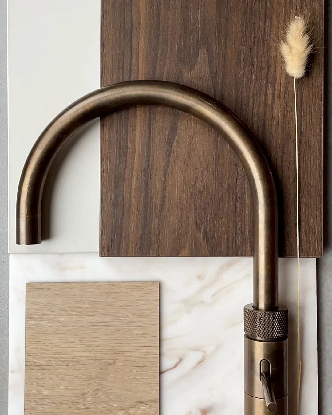 Materiaalbord voor een keuken met donker hout, licht hout, licht steen en een bronskleurige kraan