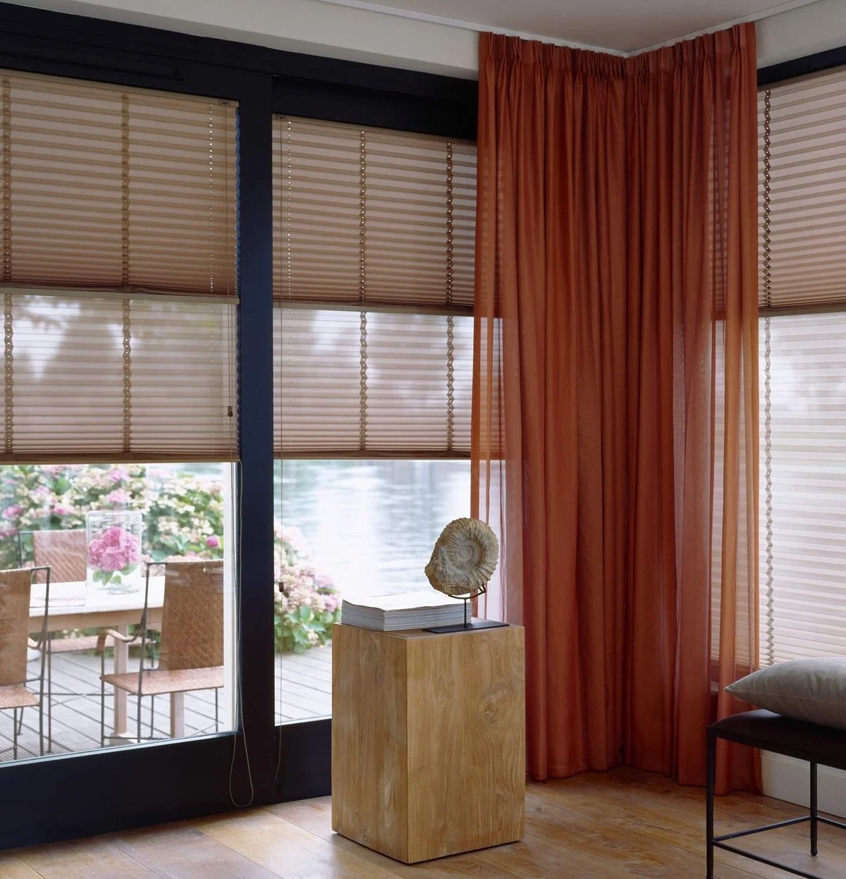 Woonkamer met terracotta vloergordijnen en lichtfilterende plisségordijnen