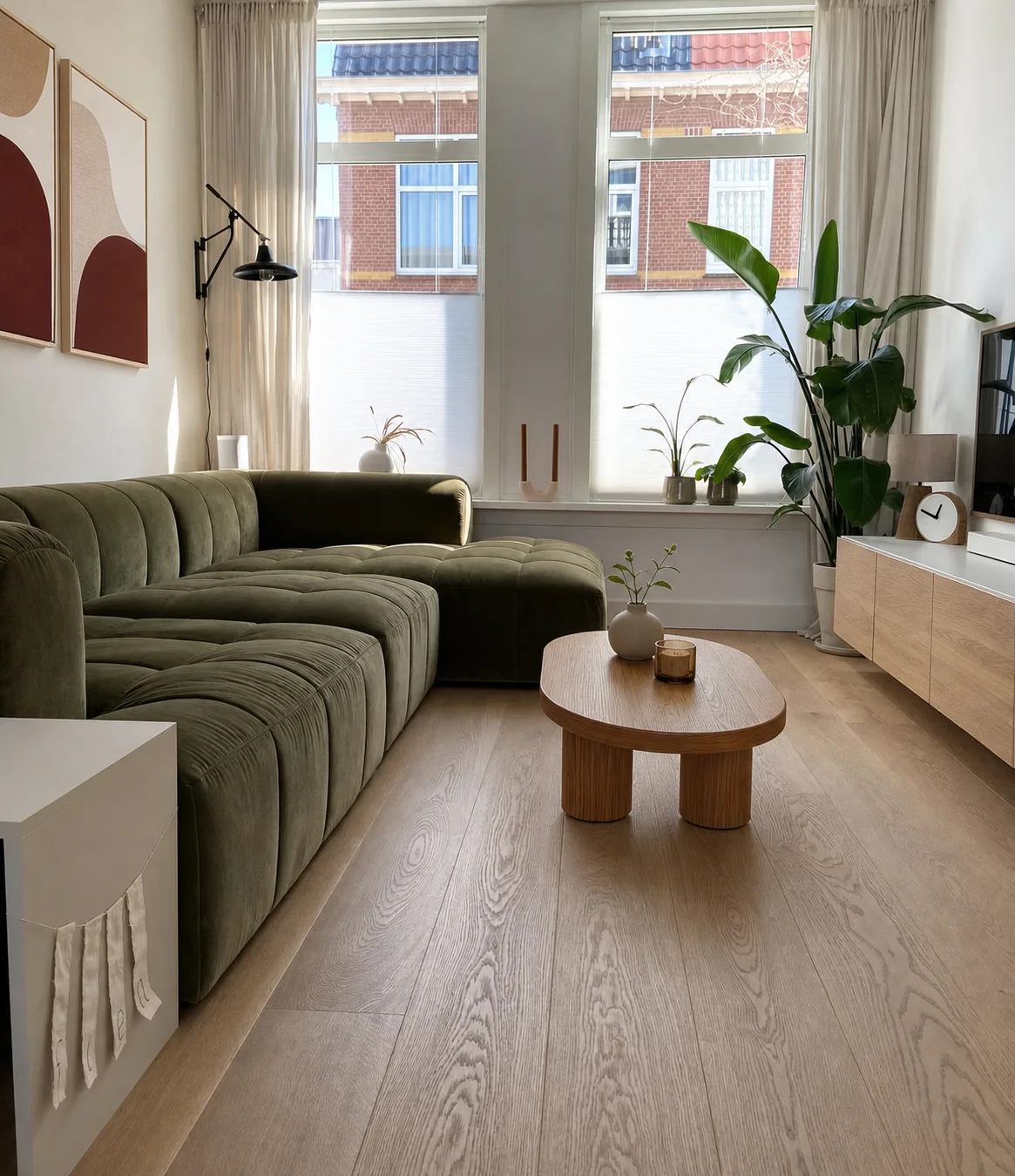 Kleine woonkamer met een olijfgroene hoekbank en compacte houten salontafel