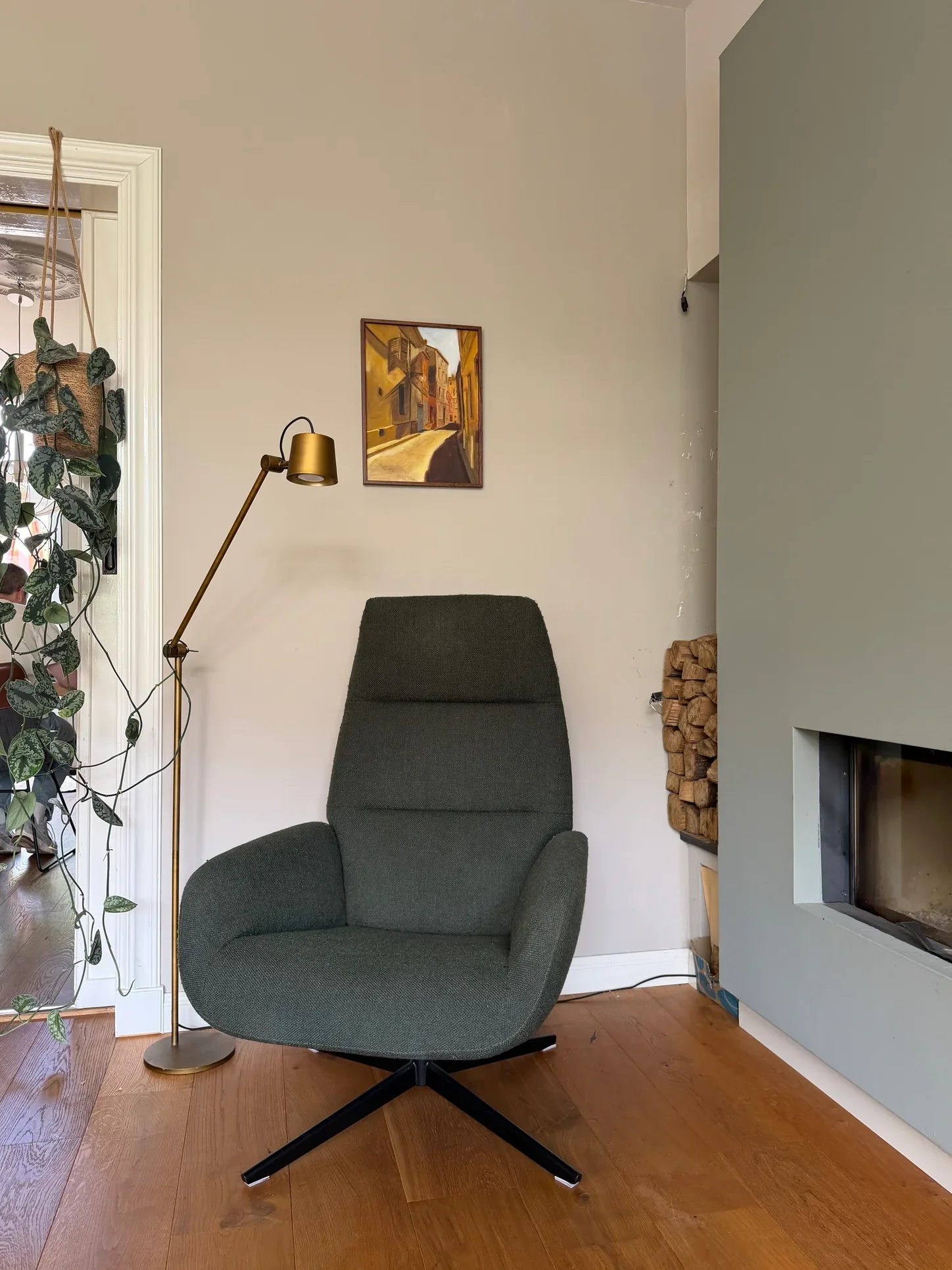 Leeshoek waarin fauteuil, lamp, kunst en haard als één geheel zijn afgestemd